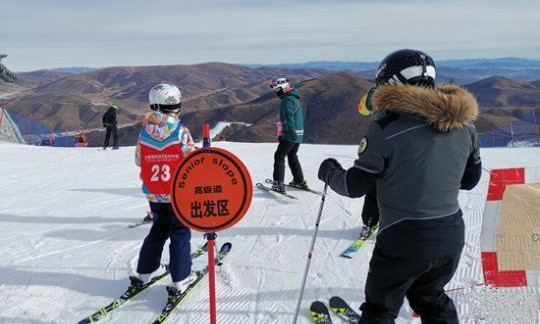 崇礼太舞滑雪场,小滑雪者在教练的带领下即将从高级道滑下。